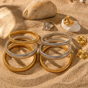 18K gold plated stackable spring bracelets and irregular rings set on natural beach pebbles