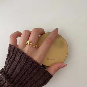 Detailed view of a gold 925 sterling silver ring with irregular lava texture on hand