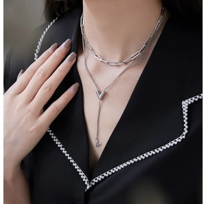 Close-up of double-layer silver V necklace with paperclip chain on model outfit