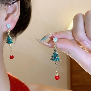Detail of Christmas tree earrings with green enamel, gold plating and red bead charm