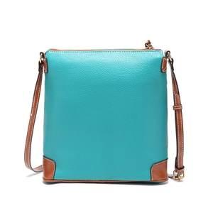 Macro detail of lychee grain leather texture and white contrast stitching on crossbody bag