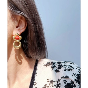 Boucles d'oreilles fleur vintage dorées avec pierre rouge et anneau sur modèle