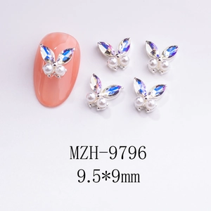 Detail of 3D silver alloy butterfly nail charms with iridescent wings and white pearls