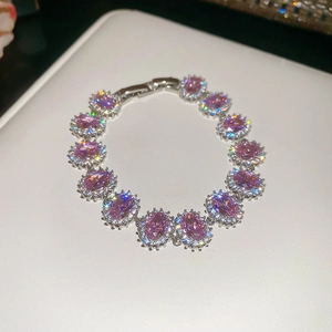 Close-up of elegant silver bracelet with oval pink zircon gems and halo setting