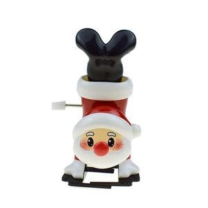 Detail of wind-up handstand Santa Claus toy showing side mechanical knob and plastic texture