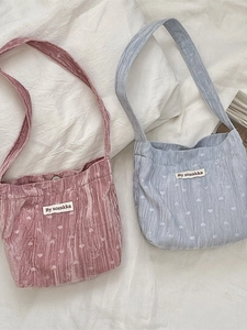 Sac fourre-tout en velours à cœurs rose et bleu sur un fond de tissu blanc épuré