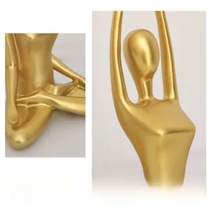 Detail of elegant gold abstract yoga sculpture showing smooth lines and metallic finish