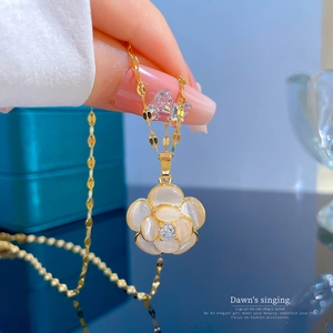 Close-up of golden titanium necklace with a cat-eye stone flower pendant for women