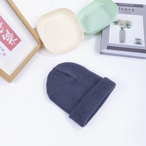 Dark gray knitted beanie hat for men and women shown in a cozy lifestyle setting