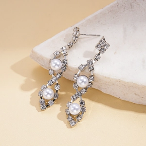 Detailed macro view of elegant silver tassel earrings with pearls and shimmering rhinestones
