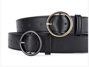 Close-up of black PU leather belts featuring round metal buckles in gold and gunmetal finish