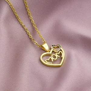 Gold Mom heart pendant necklace with zirconia on elegant pink silk background