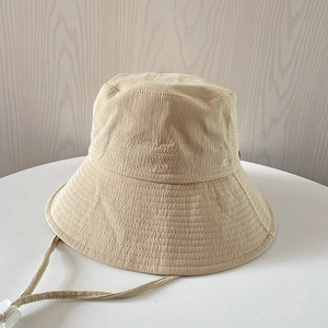 Detail showing the water ripple texture and neat stitching of the beige sun bucket hat
