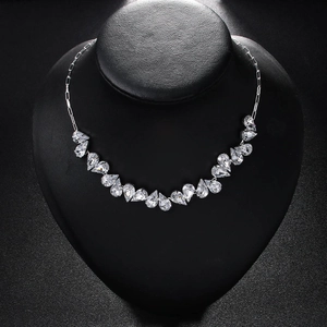 Detailed view of silver teardrop crystal necklace with prong-set gems on black bust display