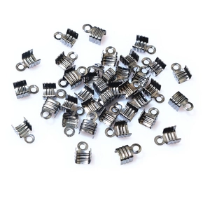 Macro shot of gun-black metal ribbon crimp ends for jewelry making on white background