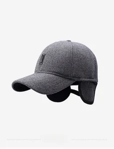 Detailed view of grey herringbone winter baseball cap featuring functional ear flaps