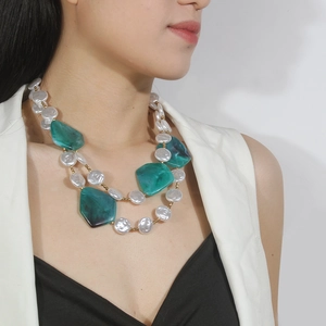 Detail of double-layer necklace with green resin blocks and white baroque pearls