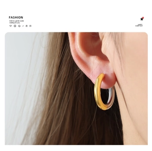 Detail of minimalist two-tone gold and silver plated hoop earrings on model
