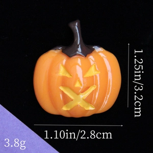 Vista macro che mostra le dimensioni del ciondolo zucca in resina: 3,2cm per 2,8cm