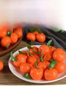 Detailed view of artificial PVC mini oranges with realistic peel texture and green leaves