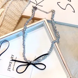 Gros plan d'une pince à cheveux à perles argentées avec un nœud noir en tissu satiné