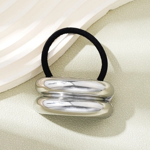 Close-up of polished silver metal tube charm on highly elastic black hair tie for ponytail