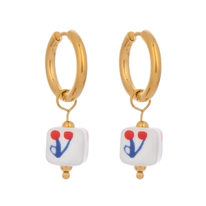 Detail of vintage enamel floral ceramic drop earrings with gold hoops and white charms