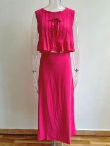 Detail of fuchsia pleated sleeveless top and matching maxi skirt set on mannequin