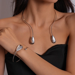 Minimalist silver-tone teardrop collar necklace and bangle set worn by a model