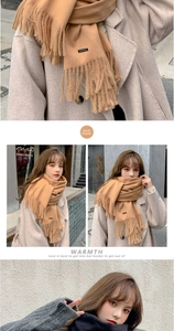 Close-up of soft deep khaki cashmere scarf featuring elegant fringe and woven brand label