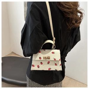 Chic white corduroy Kelly bag with red strawberry pattern and gold chain strap