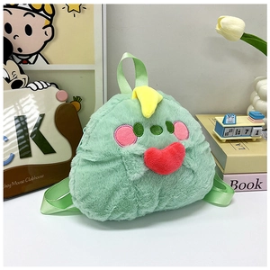 Detail of green plush dinosaur backpack with yellow horns and red heart embellishment