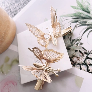 Pair of golden butterfly hair clips with intricate hollow metal design for women