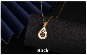 Macro shot of the polished gold heart pendant back with a purple zircon stone setting
