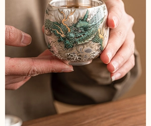 Close-up of a premium ceramic teacup with exquisite green dragon and wave pattern