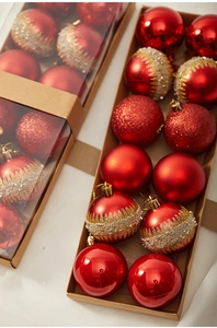 Close-up of red and gold Christmas balls with matte and glitter textures in kraft box