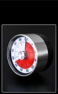 Macro shot of mechanical kitchen timer with brushed steel case and red dial display