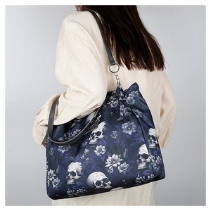Detail showing skull and flower pattern on dark blue oxford shoulder bag with black strap