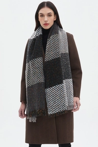 Close-up of thick checkered scarf in dark tones with tassel details for winter comfort