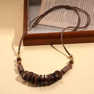 Bohemian wood bead and coconut shell necklace with floral accents on vintage book background