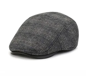 Detail der dunkelgrauen Tweed-Textur und des Retro-Karomusters der klassischen Schiebermütze