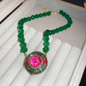 Vintage emerald green bead necklace with large pink crystal pendant in luxury jewelry box