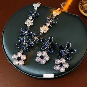 Luxury blue zircon flower pendant necklace and earrings set on black leather stand