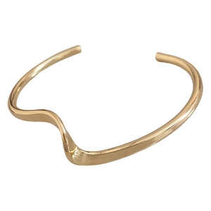 Minimalist gold wavy open bangle bracelet with a polished metallic finish for women