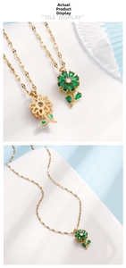 Detailed view of flower necklace with green drop-shaped gems and gold chain finish