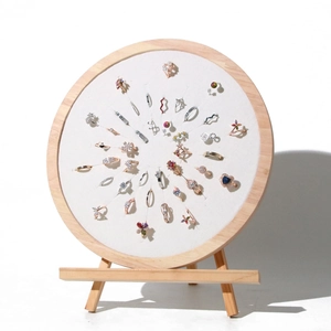 Macro view of diverse heart and geometric rings displayed on a round wooden stand