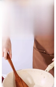Detail of rounded wooden spatula used in a non-stick pan for gentle cooking