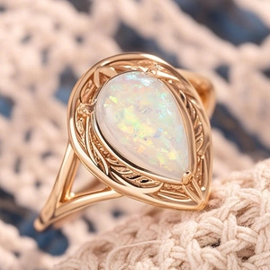 Eleganter birnenförmiger Opalring in Roségold mit Blättermuster auf Strickhintergrund