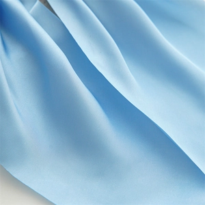 Macro shot of light blue satin fabric showing silky texture and elegant folds