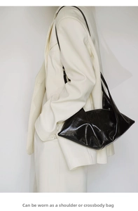 Close-up of black waxed leather hobo bag with unique geometric folded structure